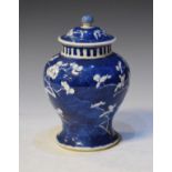 Chinese porcelain baluster shaped jar and cover decorated with prunus blossom on a blue ground,