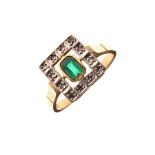 Yellow metal ring set central green stone within a surround of twelve white stones, the shank