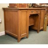 Edwardian golden oak twin pedestal desk with skiver inset top over frieze drawer between cupboards