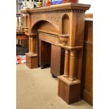 Impressive early 20th century carved walnut fire surround of inverted breakfront design with