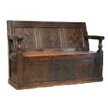 17th Century and later oak box settle, the channel moulded top rail over three panel back carved