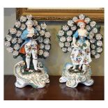 Pair of Derby style porcelain figures depicting a young gallant and lady, each standing before a