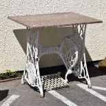 White painted cast iron Singer sewing machine table base with later pink granite rectangular top