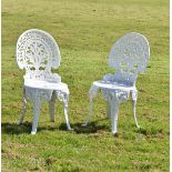 Pair of white painted aluminium garden chairs, each with shell shaped back and circular seat