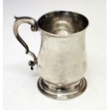 George III silver baluster shaped mug having a scroll handle and standing on a circular foot,
