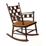 Late 19th Century Arts & Crafts oak rocking chair, the open five rung back with ten various embossed