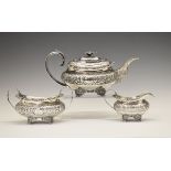 George IV silver three piece tea service, each piece with allover foliate decoration, the teapot