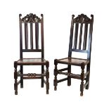 Pair of early 18th Century carved oak hall chairs, each having a scroll carved cresting rail over