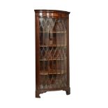 20th Century mahogany floor standing bowfront corner cabinet, the moulded dentil cornice over glazed