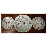 Three Chinese porcelain plates, each decorated in the Famille Rose style with birds and insects
