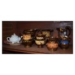 Seven assorted copper lustre pottery jugs, together with a later shell teapot and a puce lustre