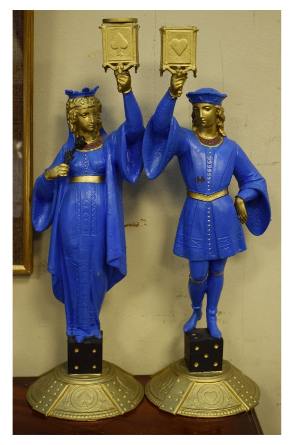 Pair of painted spelter figural candlesticks, each modelled as a robed figure holding aloft a socket