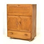 Ercol elm side cabinet with fall front upper section over twin cupboards and base drawer Condition: