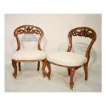 Pair of Victorian walnut framed nursing chairs, each with leaf carved open back, on French