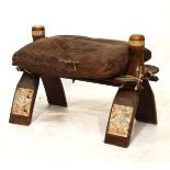 Middle Eastern camel stool with stitched decorated leather cushion on wishbone supports decorated