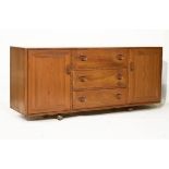Ercol elm sideboard of three drawers flanked by cupboards Condition: