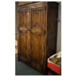 Mid 20th Century oak linen fold double wardrobe with carved two panel doors enclosing shelf over