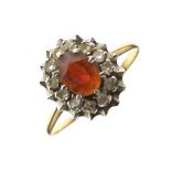 Yellow metal ring set central red stone within a diamond surround, size N, 4g approx gross