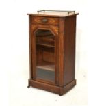 Late 19th Century inlaid walnut music cabinet with tubular three quarter gallery over canted top,