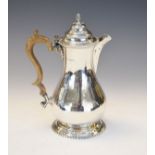 George V silver baluster shaped hot water jug, the hinged cover having a gadrooned edge, standing on