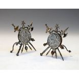 Pair of white metal menu holders, each formed as 'Weapons Of War' and inset with a Maltese 15 Tari