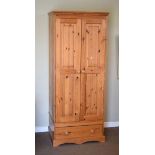 Modern yellow pine double wardrobe with panelled doors over base drawer, together with a similar