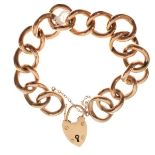 Yellow metal curb link bracelet of large hollow links to a 9ct gold heart shaped padlock, total 25.