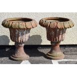 Pair of terracotta garden urns, each of campana form with leaf moulded rim on spreading socle