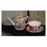 Chinese enamel decorated tea pot with exotic birds amongst foliage, tea cup and saucer and a celadon