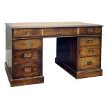 Early 20th Century stained beech twin pedestal campaign style desk having inset writing surface,