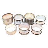 Group of seven assorted napkin rings comprising: five various hallmarked silver examples, 3.7toz,