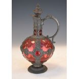 Early 20th Century cranberry glass pewter clad ewer with stopper decorated with baroque strap work