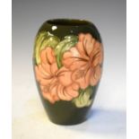 Modern Moorcroft ovoid vase decorated with the Hibiscus pattern on a green ground, 18cm high