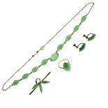 Yellow metal bar brooch set jade panels, a similar necklet and an unmarked yellow metal ring and