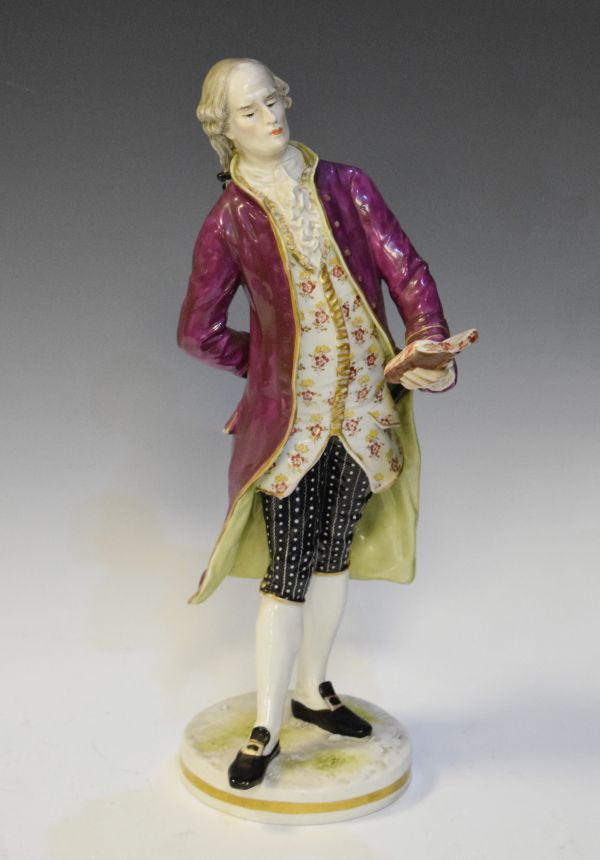 Late 19th Century Continental porcelain figure depicting a standing nobleman reading from a book,