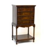 Early 20th Century oak chest on stand of small proportions having four bead edged drawers, each with