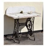 Singer sewing machine on cast iron treadle base, fitted with a grey veined marble top, together with