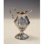 Late Victorian silver pedestal cream jug of bulbous design with repousse decoration on gadrooned