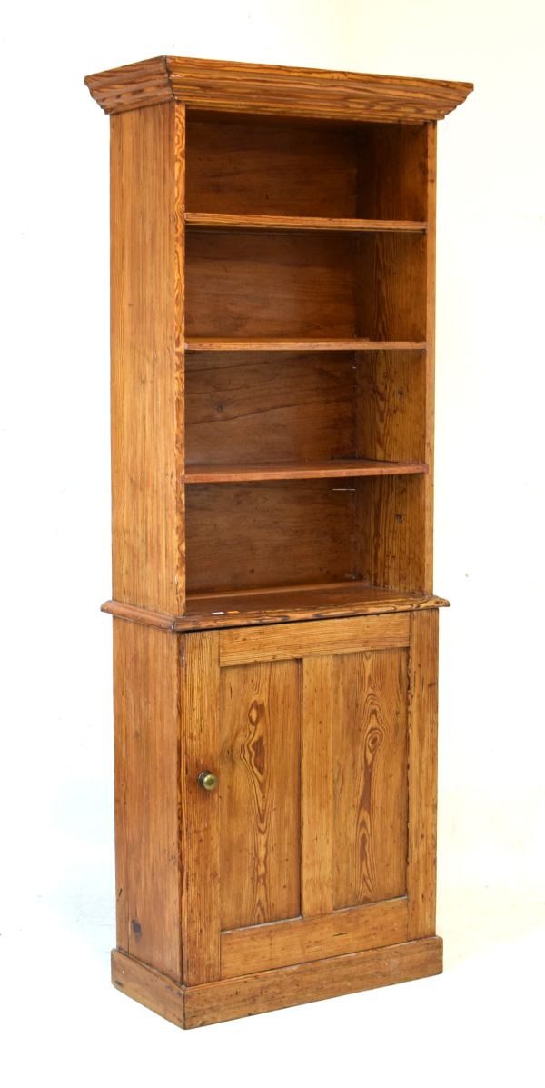 Late 19th/early 20th Century pitch pine bookcase on cabinet, the moulded cornice over four