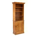 Late 19th/early 20th Century pitch pine bookcase on cabinet, the moulded cornice over four