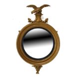 19th Century gilt framed circular convex wall mirror typically surmounted with an eagle and having a