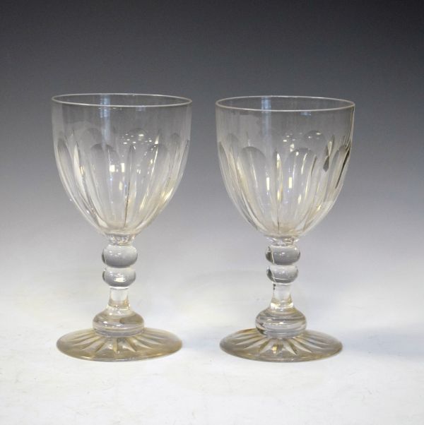 Two large late 19th/early 20th Century cut glass goblets, each having a facet cut bowl, knopped stem