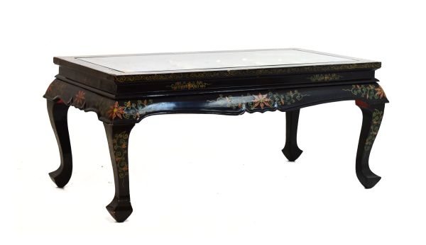 20th Century Oriental black lacquered coffee table, the rectangular top decorated in relief with