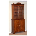 19th Century mahogany two section bookcase, the upper section with a raised pediment, fitted four