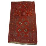 Middle Eastern wool prayer rug having typical geometric and architectural decoration on a red ground