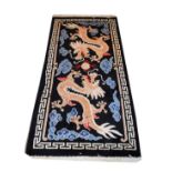Modern Chinese rug decorated with dragons on a black ground within a Greek key border, 190cm x