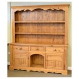 Yellow pine dresser and rack, the upper stage with moulded cornice and apron over two shelves,