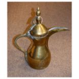 Middle Eastern brass ewer of bulbous form with domed cover, long spout and cast studded handle