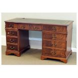 Reproduction mahogany twin pedestal desk having a gilt-tooled green skiver within moulded canted