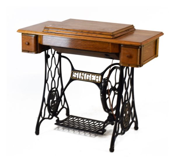 Oak cased Singer sewing machine on iron treadle base Condition: